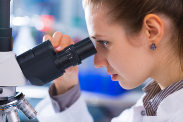 Young scientist studying Pathological microorganism  in microscope