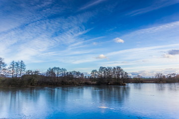 Cold lake under a blue sky in the winter. Czech republic.