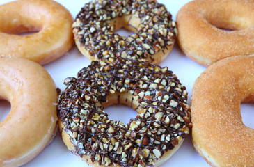 Close-up of six doughnuts in different flavors, with selective focus