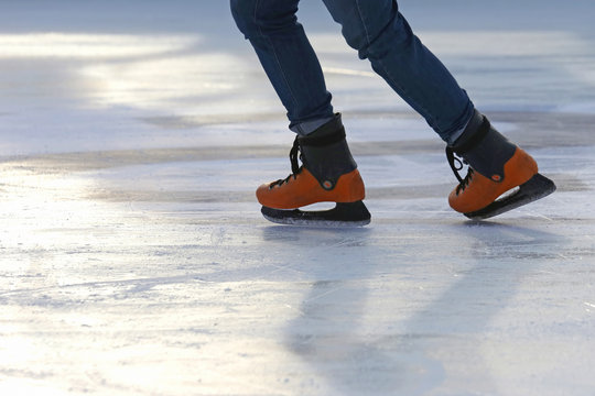 the legs of a man skating on the ice rink.