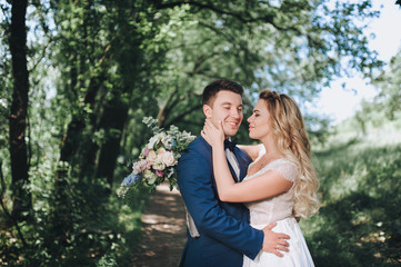 The newlyweds hug for a walk in the woods. Wedding in nature.