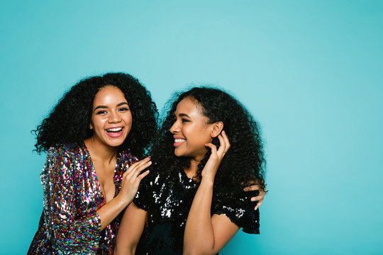 Laughing young women in stylish clothing. Best friends posing in studio.