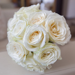 Bridal bouquet from white roses on armrest of sofa