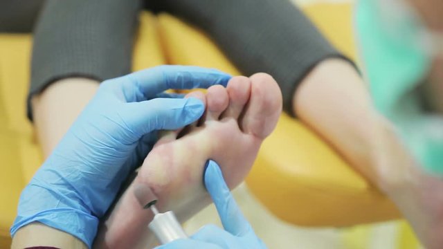 doctor of podiatr is making pedicure to the young girl in the clinic
