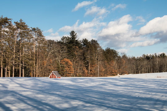 Landscape view of a red barn in the snow