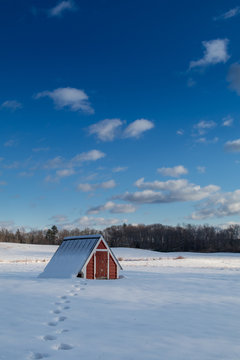 Red barn covered by the snow
