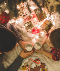 Father and son laying under christmas tree.