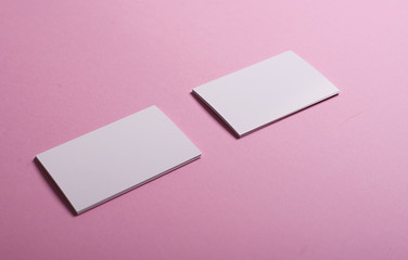 White business cards on pink background. Mockup.