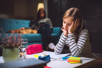 Worried girl doing homework late at night