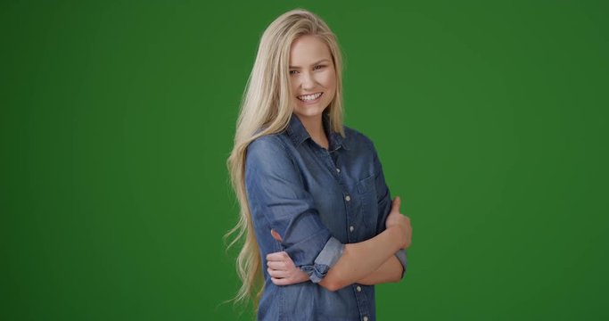 Attractive blond female smiling on green screen. On green screen to be keyed or composited.