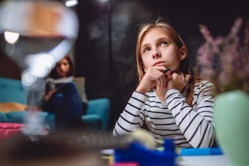 Worried girl doing homework late at night