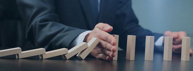 male hand placing wooden block on a tower. planing and strategy concept