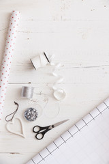 Top view on Christmas gifts wrapping materials: striped paper and decorations, ribbons and heart.