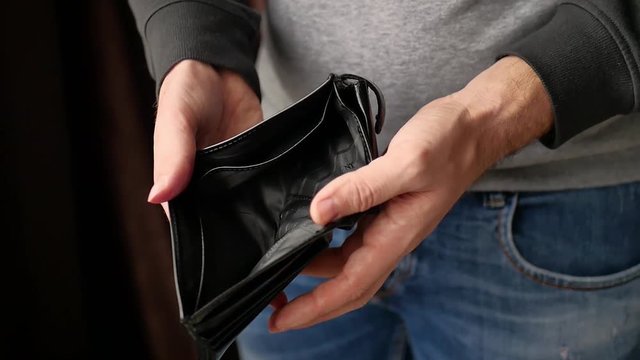 Man shows that there is no money in his wallet.