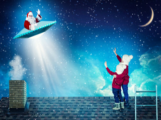 Two brothers on Christmas night stand on the roof of the house and look at Santa's flight to UFO.