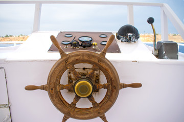 view of the captain's bridge on the yacht. wooden helm of the white yacht against the azure sea.