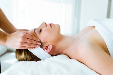 Obraz na płótnie Canvas Beautiful young woman having spa facial massage in beauty salon.
