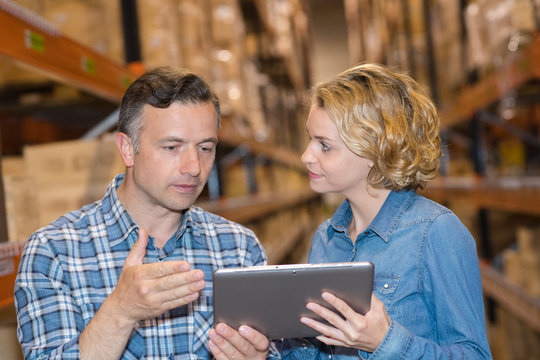 man and a woman checking inventory levels of goods