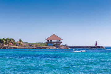 Bungalow and a lighthouse on the seashore