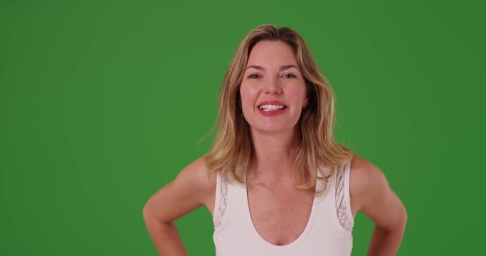 Attractive middle aged Caucasian woman looking at camera on green screen. On green screen to be keyed or composited.