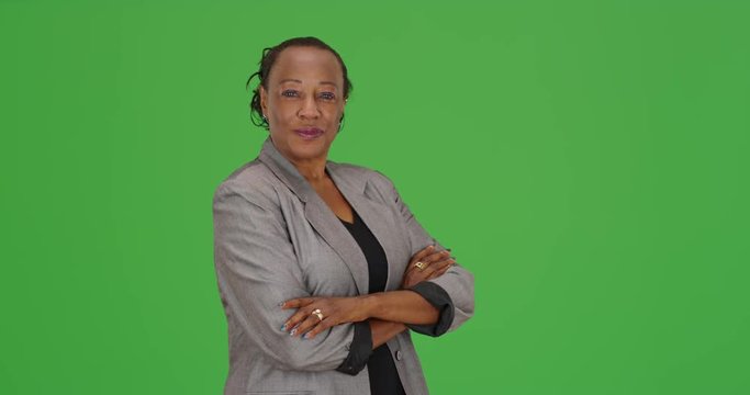 An African American businesswoman standing looking at camera on green screen. On green screen to be keyed or composited. 