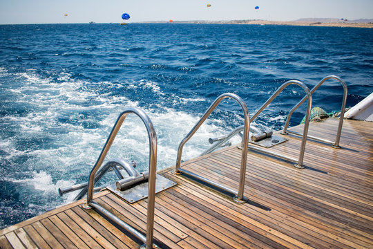 yacht's stern with two boarding ladders on a background of azure sea. great vacation. amazing summer day in open water on a boat.