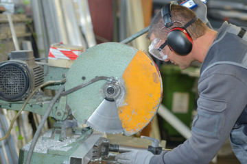 worker cutting through metal rod - obrazy, fototapety, plakaty