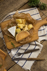 a variety of cheeses on a wooden board.