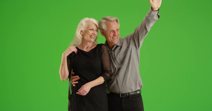 Senior couple standing trying to get a taxi on green screen. On green screen to be keyed or composited. 