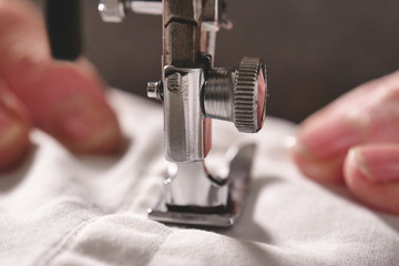 Super slow motion of a professional sewing machine stitching with white thread an Italian haute...