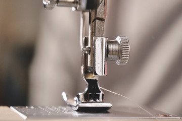 Super slow motion of a professional sewing machine stitching with white thread an Italian haute couture fabric, The seamstress sews a high fashion outfit. concept of industry, tradition, fashion