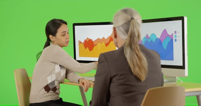 Two office professionals talk about their company's statistics on green screen. On green screen to be keyed or composited. 