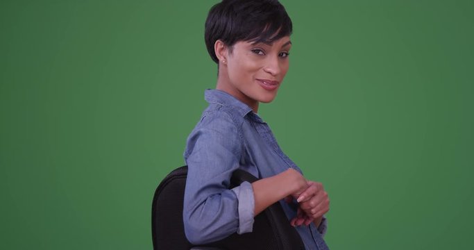 Black woman casual business professional looking over chair on green screen. On green screen to be keyed or composited. 
