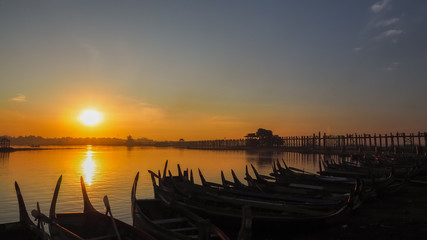 Sunset in U Bein bridge with vintage boat Myanmar. U Bein bridge is longest teak