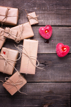 Gift boxes with presents  and  two burning candles in form of heart