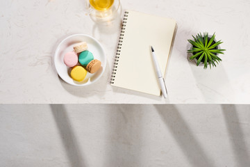Minimal styled flat lay table with open notebook, croissant and tea.