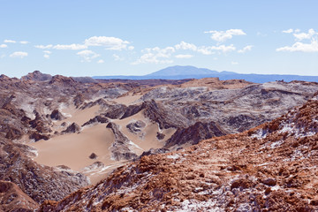 Colorful rock formations at high altitude in the desert with mountains on horizon. Natural wonders of Atacama Desert, Chile, South America.
