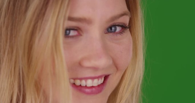 Close up of smiling happy laughing millennial blonde woman looking at camera  on green screen. On green screen to be keyed or composited. 