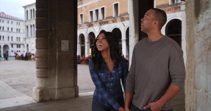 Traveling black boyfriend and girlfriend in love walk around Venice, Italy
