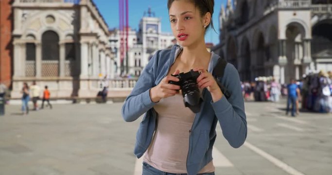 Cute Latina tourist sightseeing in Venice takes picture in St. Mark's square