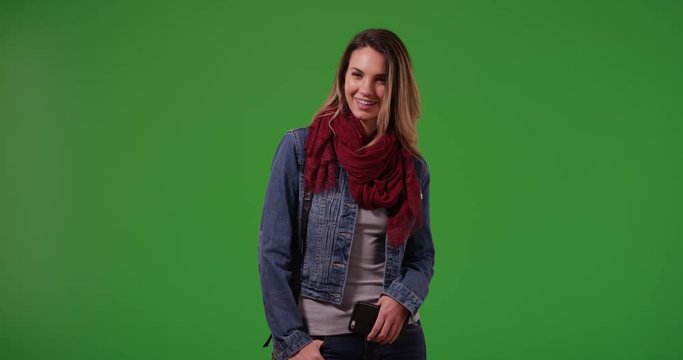 Portrait of smiling millennial girl standing on green screen. On green screen to be keyed or composited.