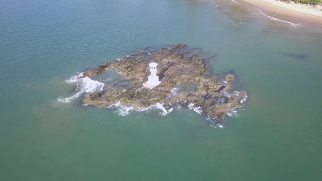 4k aerial view of a small lighthouse off a tropical beach in Thailand