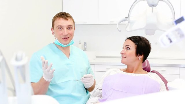 adult dentist with smiling patient woman sitting in medical Center 
