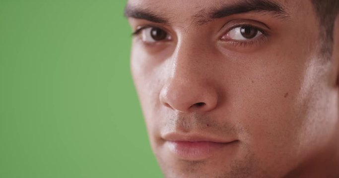 Close up of happy smiling Hispanic Millennial tourist on green screen. On green screen to be keyed or composited. 