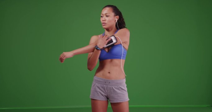 Healthy Asian woman athlete stretching on green screen. On green screen for keying or compositing. 