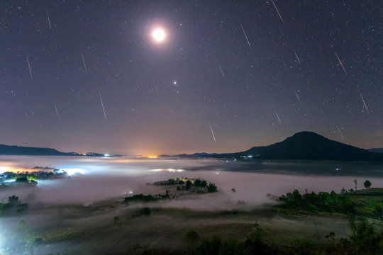 Geminid Meteor in the night sky with moon and fog at Khao Takhian Ngo View Point at Khao-kho Phetchabun,Thailand