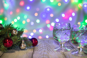 Fototapeta na wymiar Two glasses of christmas champagne with christmas tree decorated of red and silver balls against light bokeh background