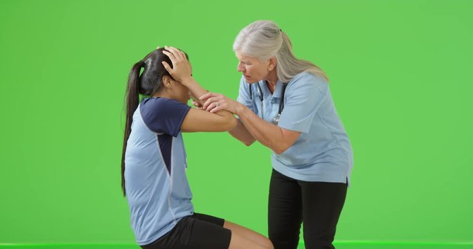 A young soccer player gets an injury on green screen. On green screen to be keyed or composited. 