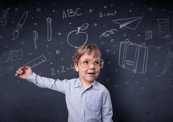 Little boy in front of a drawn up blackboard