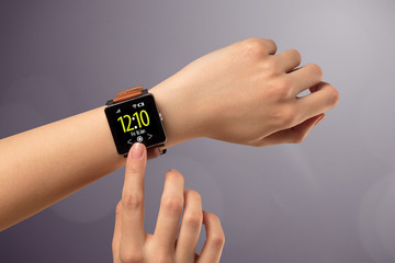 Female hand wearing and pressing smartwatch